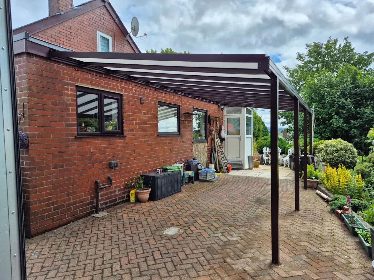 Dark-framed patio canopy installed against a brick home